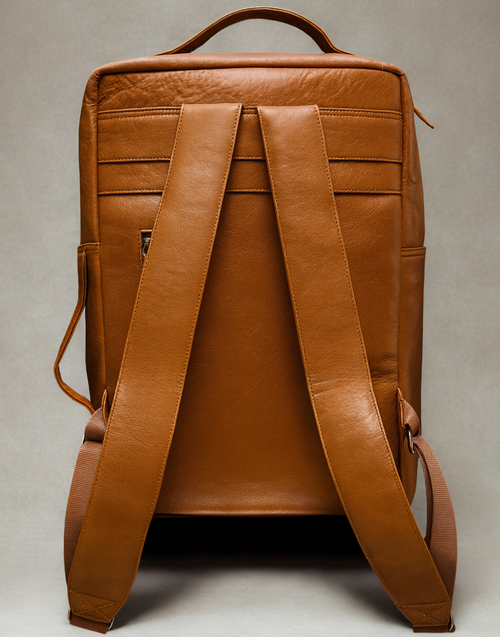 Brown leather backpack on a light gray background