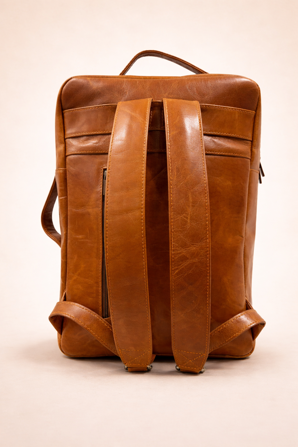 Brown leather backpack on a beige background