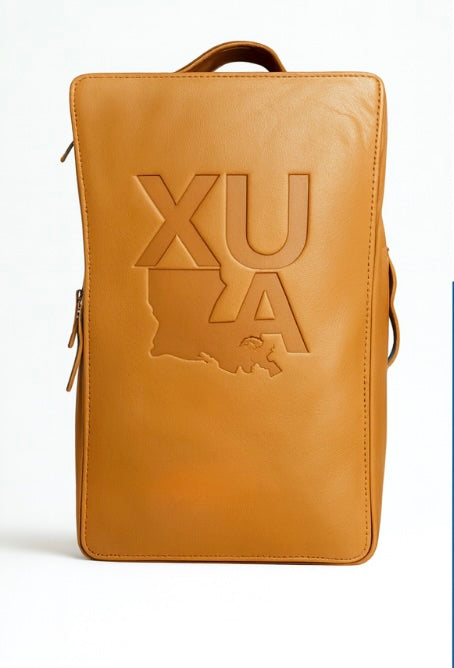 Tan leather backpack with 'XULA' logo on a white background