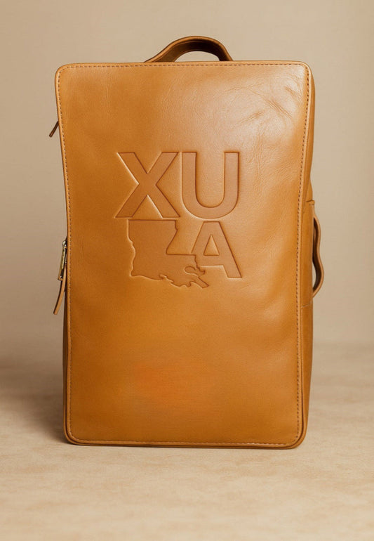 Brown leather backpack with 'XU' logo on a beige background