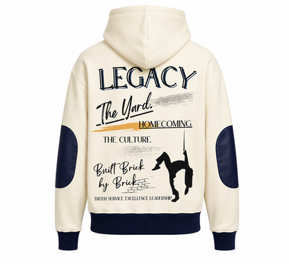 The back view of The Legacy HBCU Hoodie. An off-white hooded sweatshirt shown from the back, featuring navy blue elbow patches, ribbed cuffs and hem, and a large graphic print with text and a silhouette of an HBCU drum major.